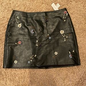 Gorgeous leather dark green skirt (looks black) with metal button flowers